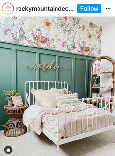 a white metal bed sitting in a bedroom next to a wall with flowers on it