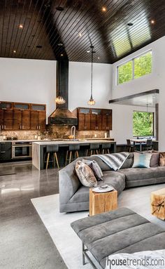 a living room filled with furniture next to a kitchen