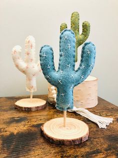 two small cactus sculptures sitting on top of a wooden table