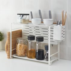 kitchen utensils and containers are arranged on the shelf in front of the counter