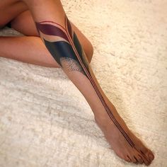 a woman's leg with an abstract tattoo on her left arm and bottom half