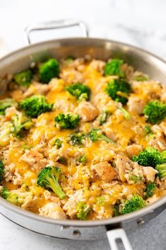 a skillet filled with chicken and broccoli on top of a white counter