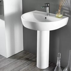 a white pedestal sink sitting next to a toilet