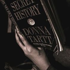 a person holding up a book in their hands with the title secret history written on it