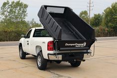 a white pickup truck with a dumpster in the back