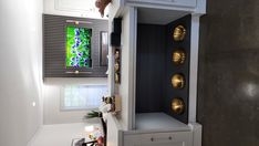 a white cabinet with drawers and a tv mounted on it's side in a room