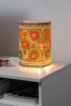 a lamp that is sitting on top of a white table next to a book shelf