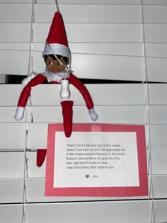 an elf hanging from the ceiling with a note attached to it's back end