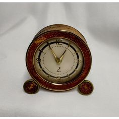 an old fashioned clock with two red circles around it