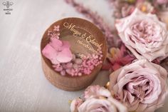 some pink flowers and a wooden box on a table