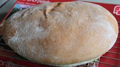 a loaf of bread sitting on top of a cooling rack next to a red package