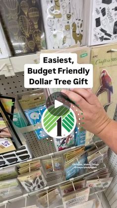 a woman is holding a dollar tree gift in front of some cards and magnets