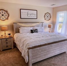 a bedroom with a large bed and two clocks on the wall