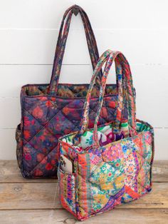 two colorful bags sitting on top of a wooden table