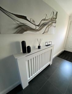 a white radiator sitting next to a painting on the wall in a room