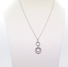 A silver double circle CZ necklace showcases an elegant design with two interlocking circles made of polished silver, symbolizing connection and unity. The circles are embellished with sparkling cubic zirconia (CZ) stones, adding a touch of glamour and sophistication, making it a versatile piece for both casual and formal wear.