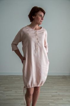 Loose fit linen button up tunic. Soft linen dress with three quarter sleeve and intricate details. FEATURES:Boat necklineButton up frontTie up bottomThree quarters dolman sleeveRuffle sidesPocketsModel is 174 cm/5'7" tall, size S-M. SIZE:S-M | EU 36-38 | US 6-10-Chest 110 cm / 43.3"-Back Center Length 93 cm / 36.6"-Hips 118 cm | 46.4"M-L | EU 38-42 | US 10-12L-XL | EU 42-46 | US 12-16COMPOSITION:100% - local medium weight linenOeko-Tex certified 100 % linen fabric* IMPORTANT: We can make clothes Casual Linen Dress With Button Cuffs For Spring, Summer Linen Dress With Button Cuffs For Daywear, Spring Linen Dress With Button Closure, Spring Button-up Tunic With Buttons, Spring Daywear Linen Dress With Button Closure, Fitted Linen Tunic For Summer, Spring Linen Tunic With Buttons, Summer Tunic With Buttons And Relaxed Fit, Relaxed Fit Linen Dress With Buttons For Daywear