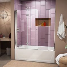 a bathroom scene with focus on the bathtub and shower stall, which is decorated in pastel pink tiles