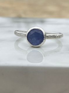 This sweet ring has a 7mm, 1.1ct round rose cut tanzanite on a cracked ice textured 2mm round band. The tanzanite is a pretty soft light purple that glows. Ethical Tanzanite Birthstone Ring, Round Tanzanite Solitaire Birthstone Ring, Tanzanite Ring With Bezel Setting, Tanzanite Birthstone Ring Gift, Everyday Sapphire Ring With Bezel Setting, Bezel Set Tanzanite Ring, Ice Texture, Sterling Silver Stackable Rings, Sweet Ring