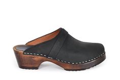 Berkeley is a classic clog with clean Scandinavian design. The clogs come in a black nubuck leather. The clogs are made on our brown stained and varnished comfy bottoms which makes them great for many different weather conditions. Heel height: 5 cm Platform height: 2.5 cm Fit: Medium width Leather Upper: Portugese black nubuck Wood: Brown stained & varnished alderwood Footbed: Brown stained alderwood for excellent moist absorption *Maguba Size Guide* EUR 35 | USA 5-5.5 (227mm | 8.94 inches) EUR Red Leather Sandals, Comfy Bottoms, Brown Mules, Clogs For Women, High Heel Clogs, Swedish Clogs, Black Clogs, Clogs Style, Slow Fashion Movement