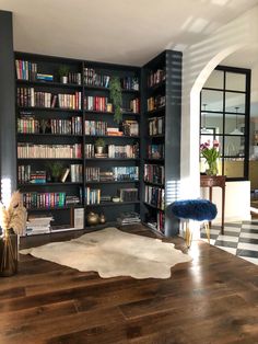 a large book shelf filled with lots of books on top of a hard wood floor