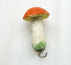 an orange and white mushroom sitting on top of snow