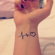 a woman's arm with a heartbeat tattoo on it and the word love written in black ink