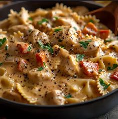 a skillet filled with pasta and chicken