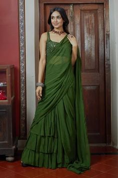 Green pre-draped saree with a tiered silhouette. Comes with mirror embroidered sleeveless blouse.
Component: 2
Pattern: Embroidery
Type Of Work: Mirror
Neckline: Square
Sleeve Type: Sleeveless
Fabric: Georgette
Color: Green
Other Details: 
Tiered silhouette
Low back with tie up and tassels
Closure: Back hook
Occasion: Destination Wedding - Aza Fashions Backless Blouse Designs Sleeveless, Arpita Mehta, Embroidery Mirror, Halter Neck Blouses, Draped Saree, Simple Saree Designs, Backless Blouse Designs, Green Mirror, Fancy Sarees Party Wear