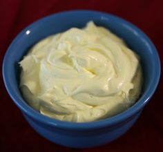 a blue bowl filled with whipped cream on top of a table