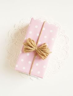 a pink gift wrapped in twine with a bow