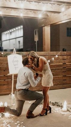 a man kneeling down next to a woman in front of a sign that says it doesn't look you up