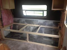 the inside of a trailer with wood framing and walls in place for windows to be installed