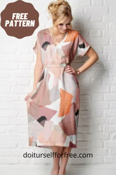 a woman standing in front of a brick wall wearing a dress with an abstract pattern