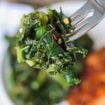 a close up of food on a fork in a bowl with broccoli and meat