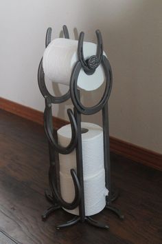 three toilet paper rolls are stacked on top of each other in this unique holder that is made out of metal