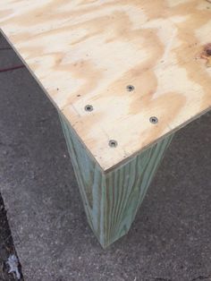 a wooden bench sitting on the side of a road