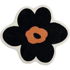 a black and orange flower shaped rug on a white surface with an orange center in the middle