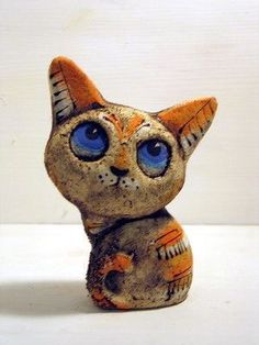 an orange and white cat figurine with blue eyes