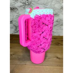 a pink crocheted coffee cup with a watermelon on the lid and handle