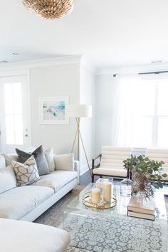 a living room filled with furniture and a chandelier hanging over the top of it