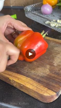 a person cutting up a bell pepper on top of a wooden cutting board