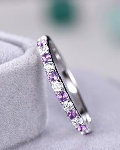 a wedding band with purple and white stones