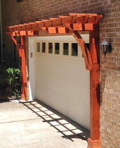 an orange pergoline on the side of a brick building with a white garage door