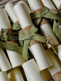 rolls of toilet paper wrapped in burlap and tied with a green satin ribbon