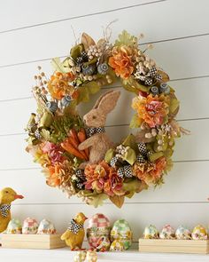 an easter wreath is hung on the wall next to other decorations and figurines