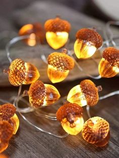 some lights that are sitting on top of a glass plate with acorns in it