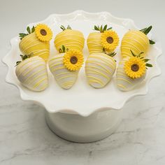 chocolate covered strawberries with sunflowers in a white bowl on a marble counter