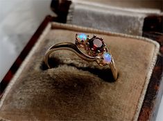 A TRULY LOVELY VINTAGE RING A Gorgeous Combination of Garnet And Opal in a Superb Solid 9ct Gold Setting The Ring comes with a set of Full British Hallmarks for authenticity Centre Garnet measures 4mm Outer Opals measure 3mm Size UK N Size USA 7 Garnet Ring Silver, Sterling Silver Garnet Ring, Gold Sapphire Ring, Silver Opal Ring, Buckle Ring, Opal Band, Sterling Silver Wedding Band, Unusual Rings, Opal Ring Gold