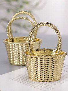 two golden baskets sitting on top of a table